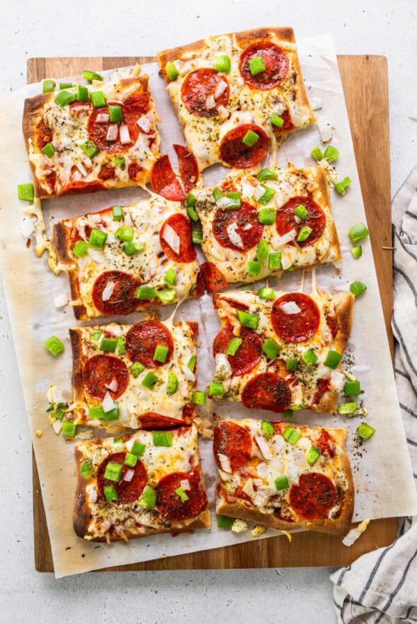 Pepperoni pizza on a cutting board.