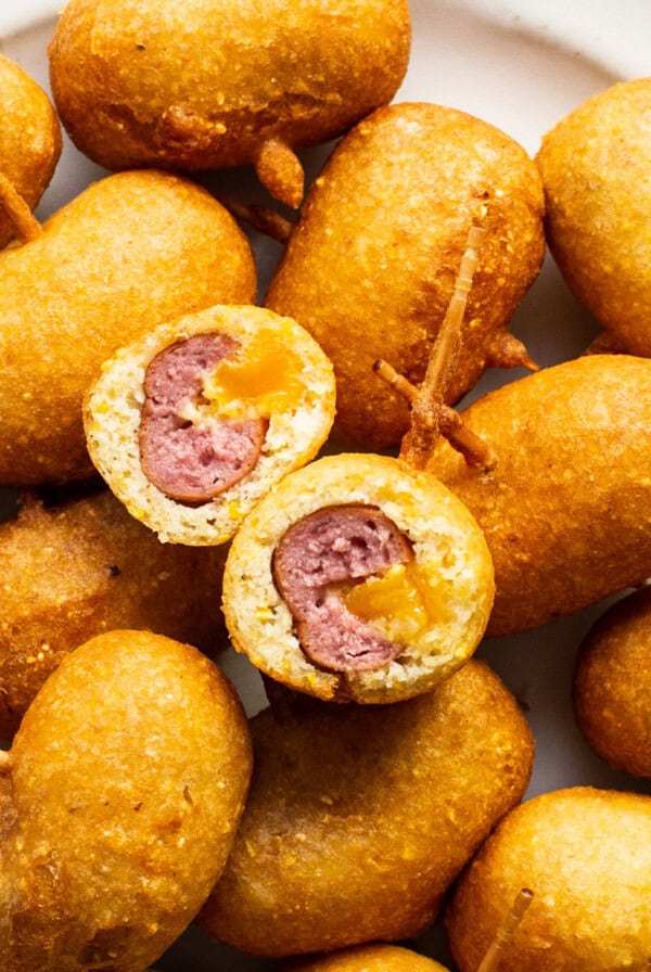 A plate full of fried meatballs with toothpicks.