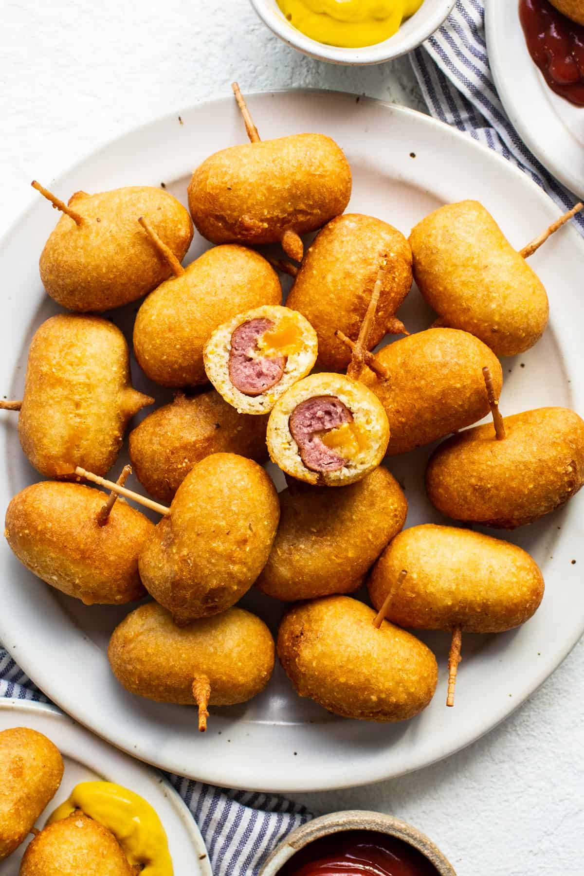 A plate of fried meatballs with ketchup and mustard.