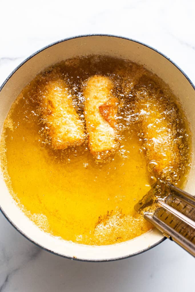 A bowl of food in a pan with a spoon in it.
