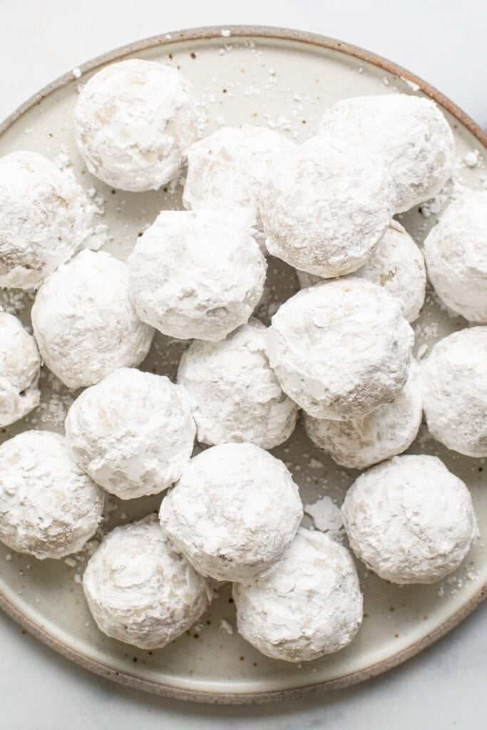 Powdered sugar cookies on a plate.