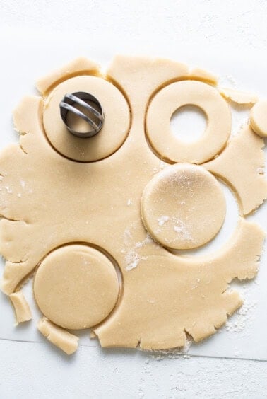 A sheet of cookie dough with a cookie cutter on it.