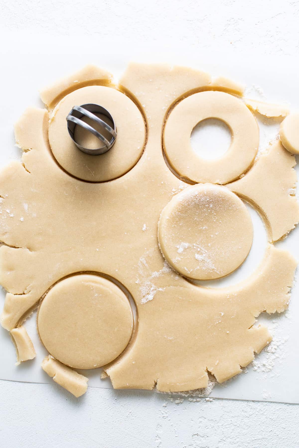 A sheet of cookie dough with a cookie cutter on it.