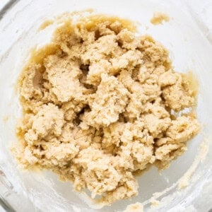 Cookie dough in a bowl on a white surface.