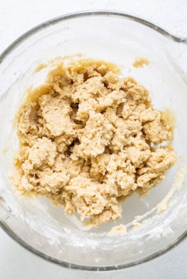 Cookie dough in a bowl on a white surface.