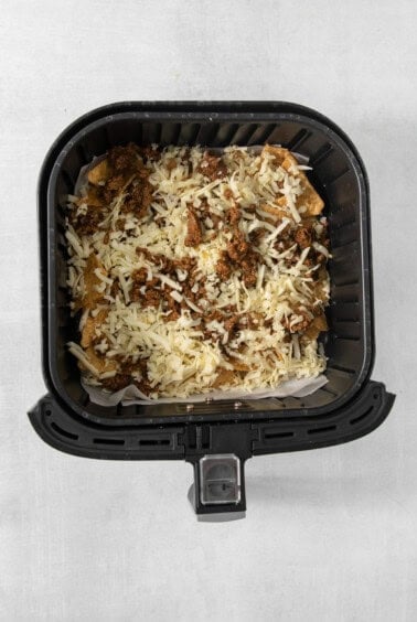 An air fryer filled with meat and cheese.