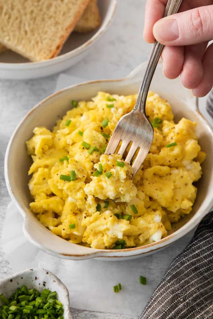 Scrambled eggs with chives in a bowl.