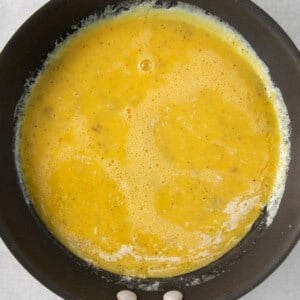 A frying pan with a yellow liquid in it.