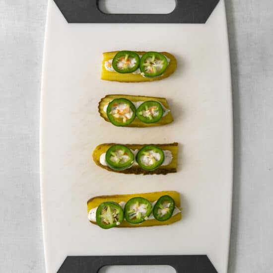 Four stuffed peppers on a cutting board.