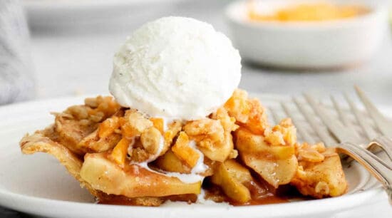 A slice of apple pie with a scoop of ice cream on top.