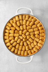 A pan full of tater tots on a white background, perfect for making cowboy casserole.