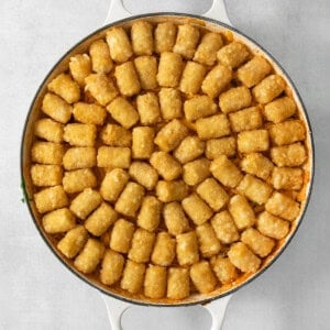 A pan full of tater tots on a white background, perfect for making cowboy casserole.