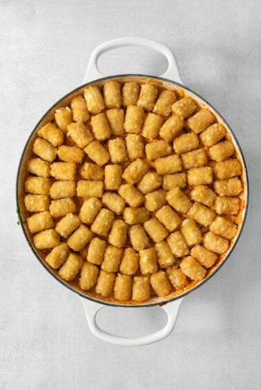 A pan full of tater tots on a white background, perfect for making cowboy casserole.