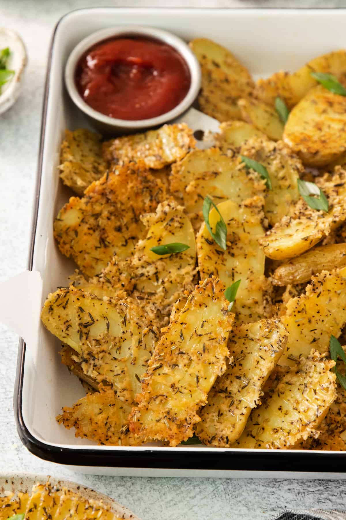 A tray of potato chips with ketchup on it.