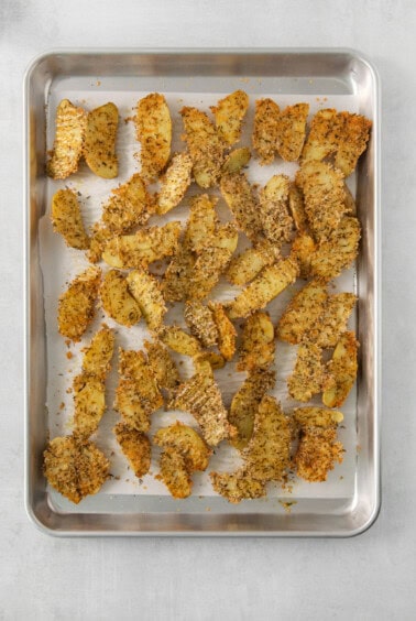 Roasted potato wedges on a baking sheet.