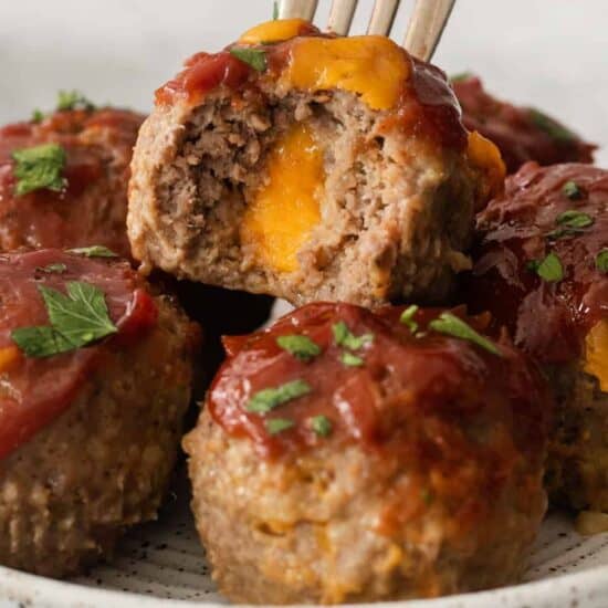 Cheesy meatballs on a plate with a fork.