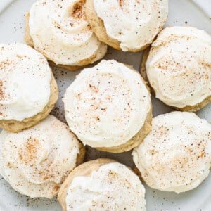 A plate of cookies with icing and cinnamon on it.