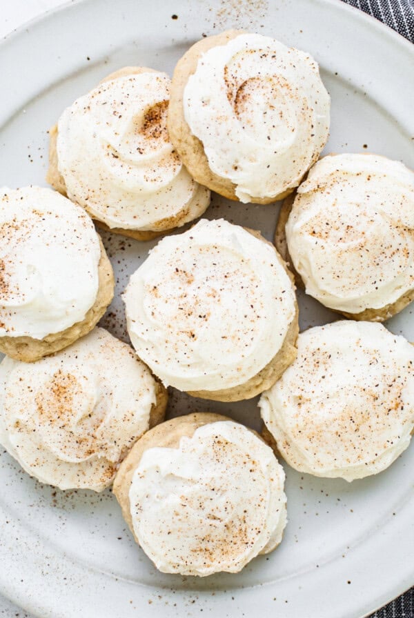 A plate of cookies with icing and cinnamon on it.