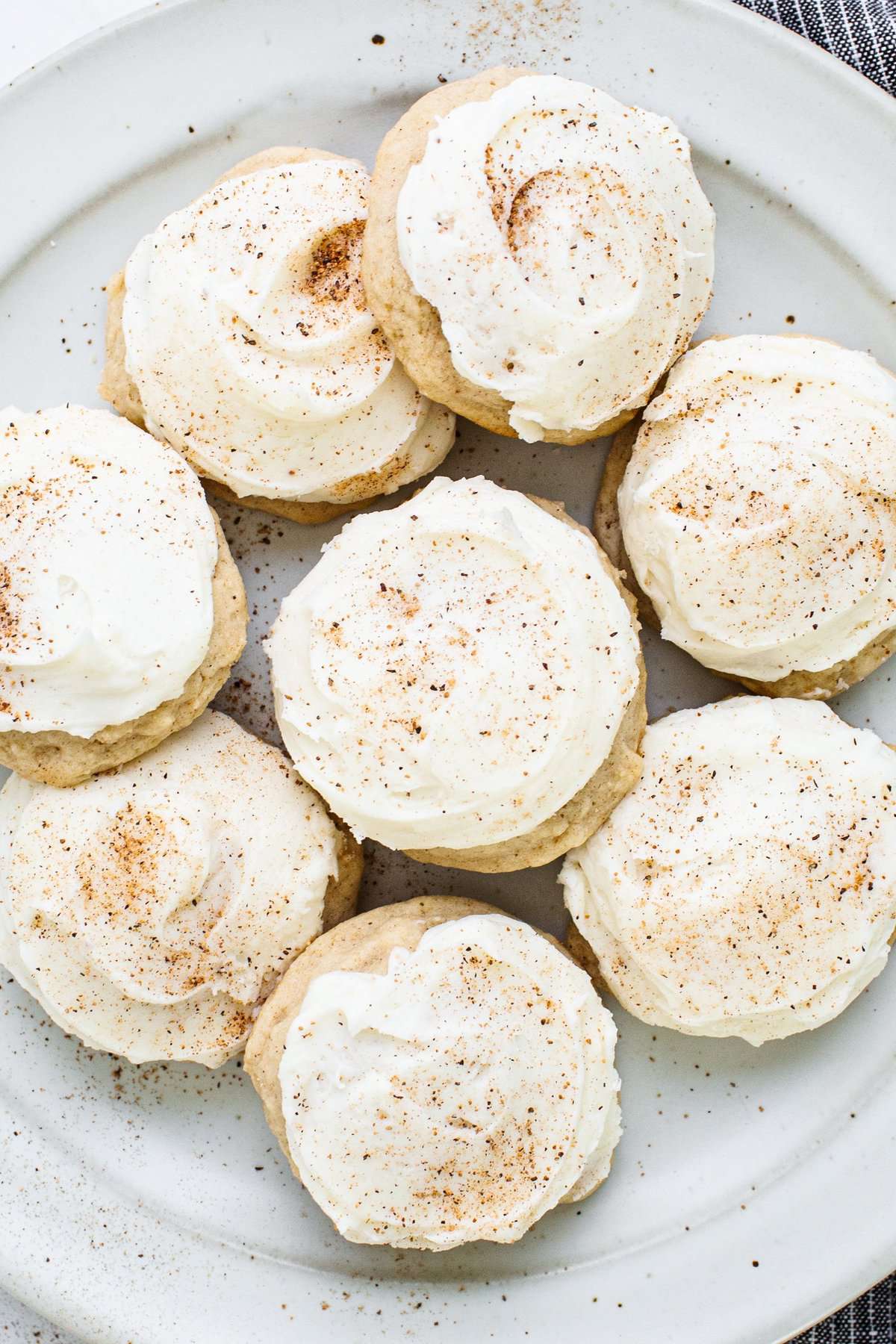 A plate of cookies with icing and cinnamon on it.