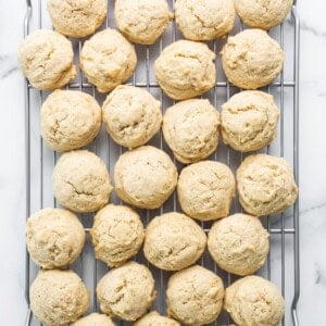 Cookies on a cooling rack on a marble countertop.