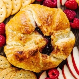 A tray of pastries, crackers, and fruit.