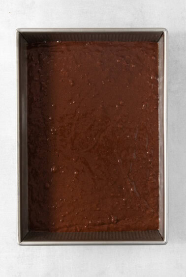 Chocolate cake in a pan on a white surface.