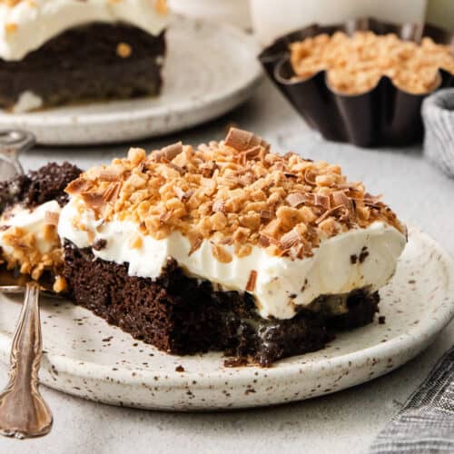 A piece of chocolate cake on a plate with a fork.