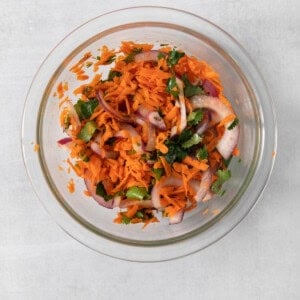 Carrot and onion salad in a glass bowl.