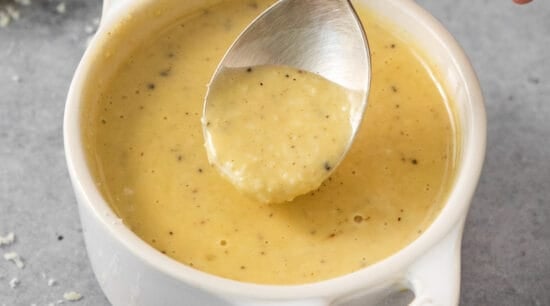 A spoonful of lemon sauce in a white bowl.
