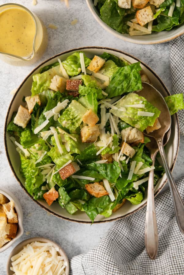 A bowl of caesar salad with croutons and dressing.