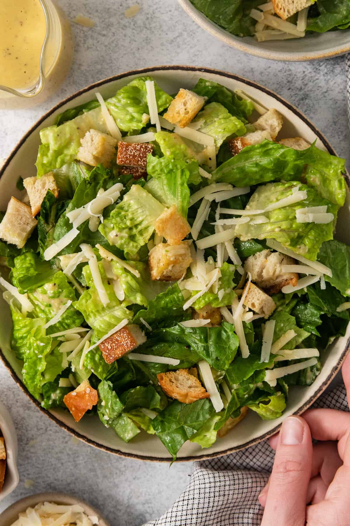 A bowl of caesar salad with croutons and dressing.