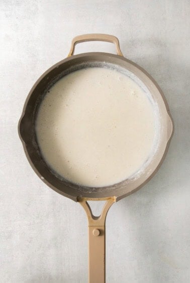 A frying pan filled with a white liquid.