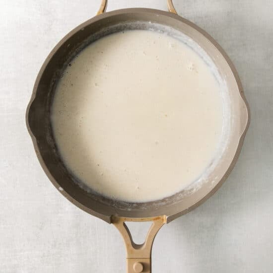 A frying pan filled with a white liquid.