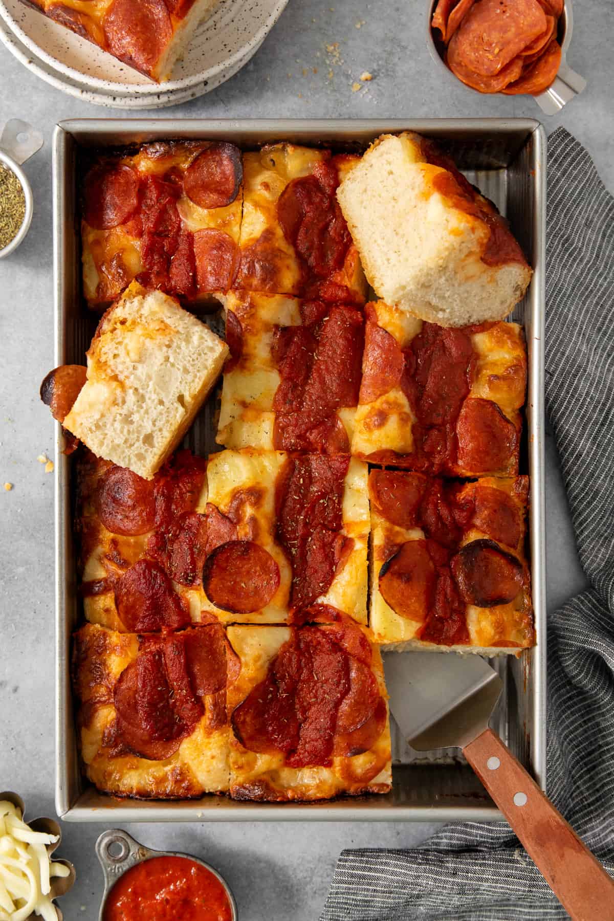 Pepperoni pizza in a pan with cheese and sauce.