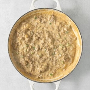 A white pan with meat in it on a table.