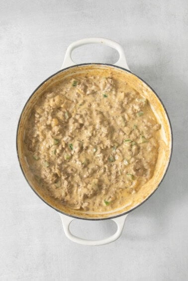 A white pan with meat in it on a table.
