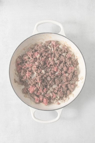 Ground beef in a skillet on a white background.
