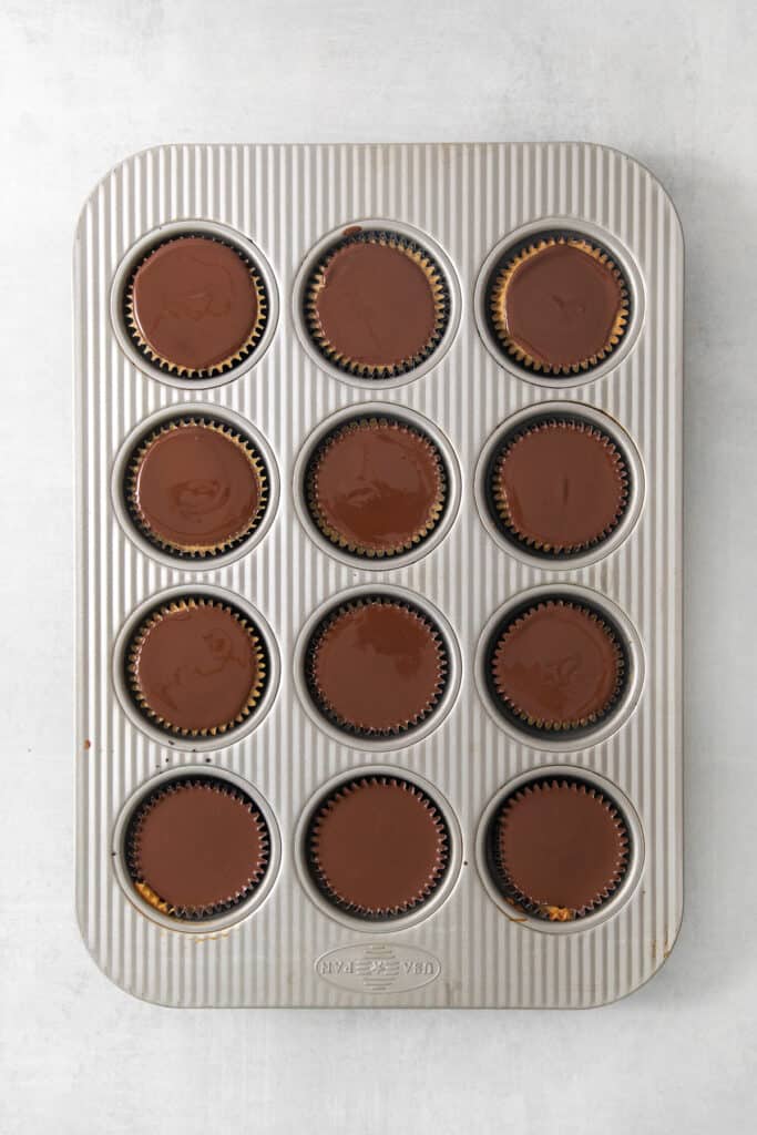 Chocolate peanut butter cups in a muffin tin.