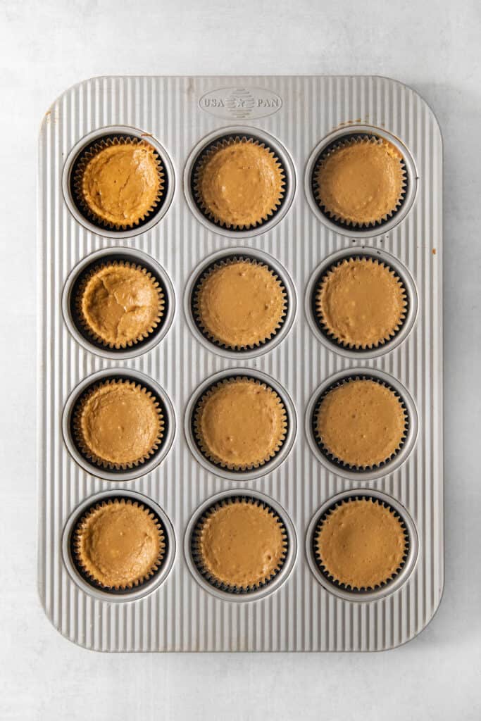 Pumpkin cupcakes in a muffin tin.