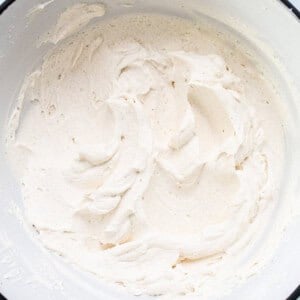 Whipped cream in a bowl on a marble countertop.