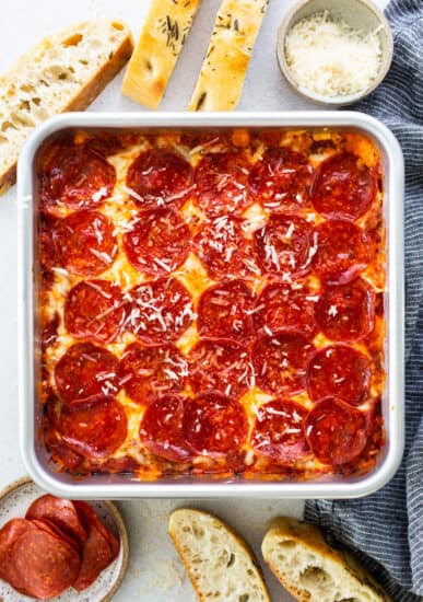 Pepperoni pizza in a baking dish with bread.
