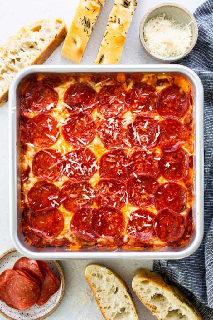 Pepperoni pizza in a baking dish with bread.