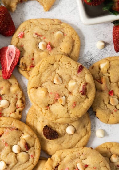 A pile of cookies with strawberries and white chocolate chips.