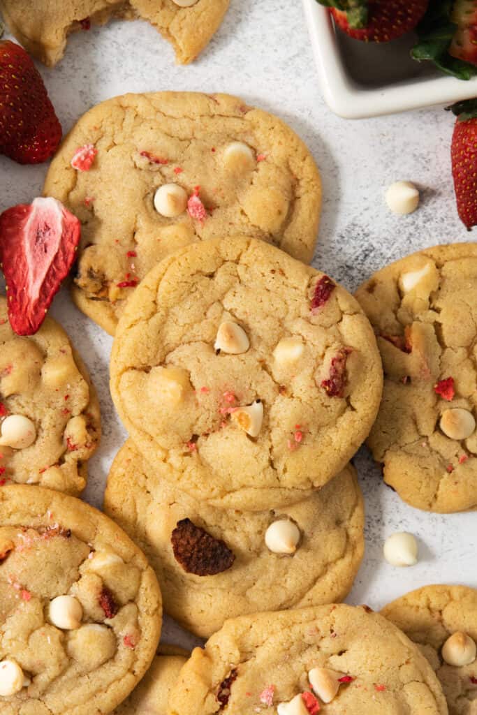 A pile of cookies with strawberries and white chocolate chips.