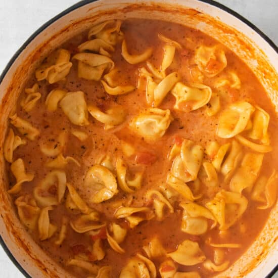 A pot of creamy tomato tortellini soup.