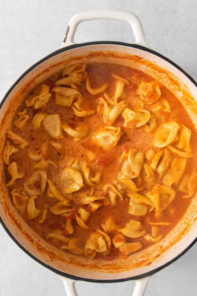 A pot of creamy tomato tortellini soup.