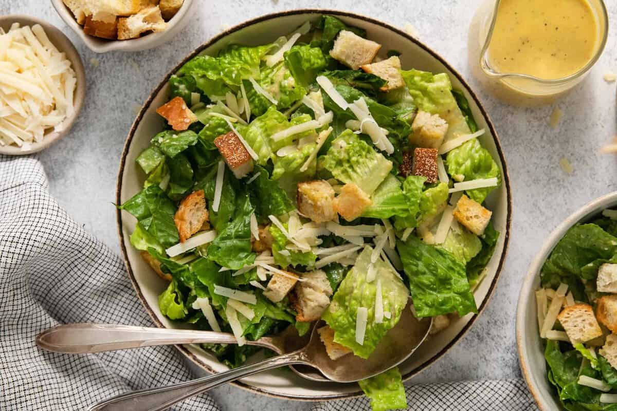 A bowl of caesar salad with croutons and dressing.