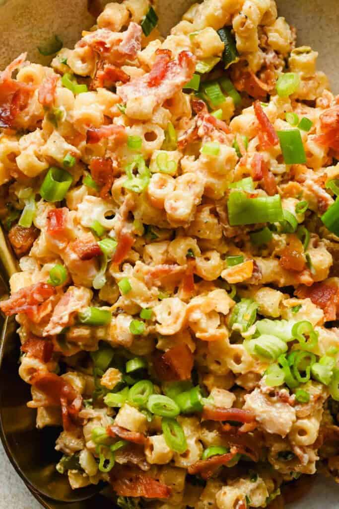 Close-up of creamy jalape&ntilde;o popper pasta salad with chopped green onions and crispy bacon pieces