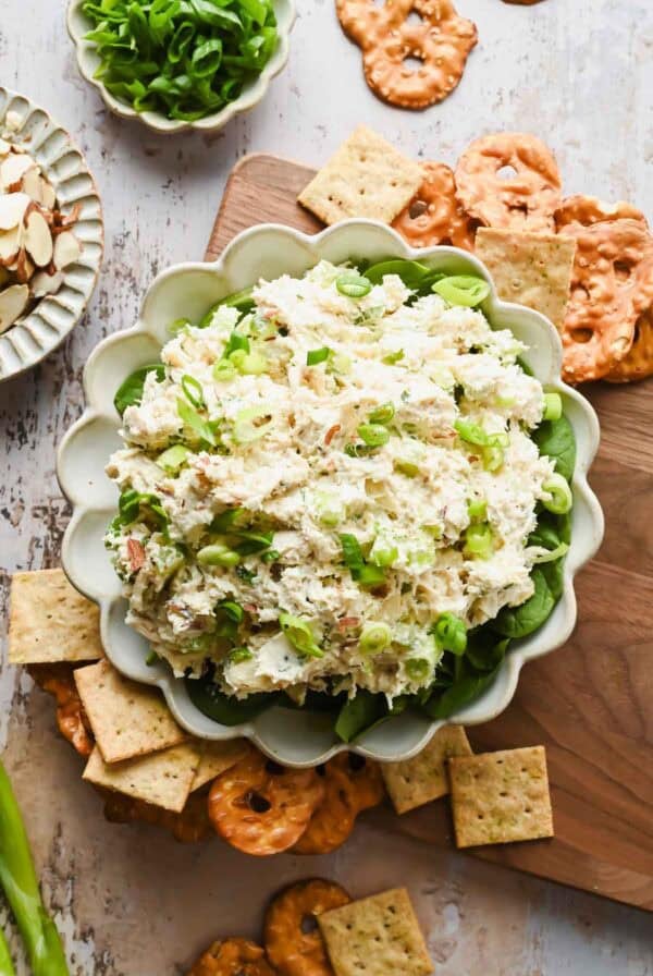 Creamy Boursin chicken salad spread served in a bowl with crackers and pretzels.