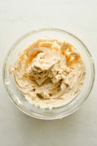 Cream cheese filling mixed with brown sugar and vanilla in a glass bowl